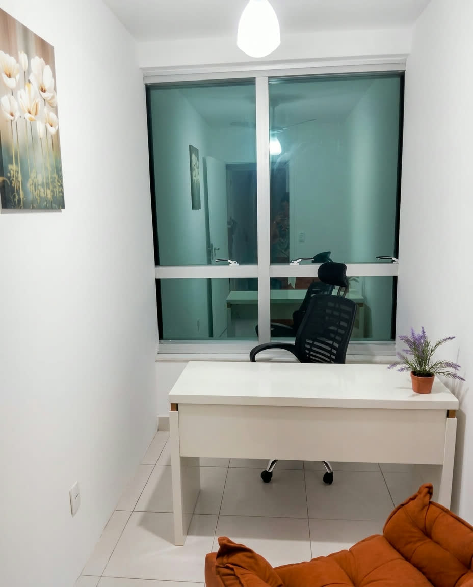 Ambiente com mesa branca, cadeira e janela ampla