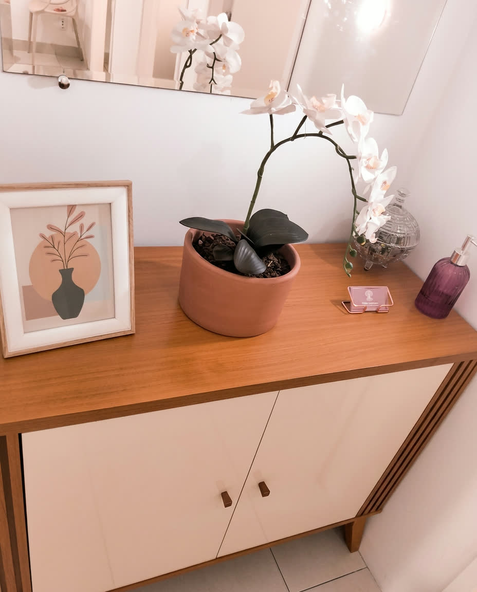 Aparador com orquídea branca e quadro decorativo